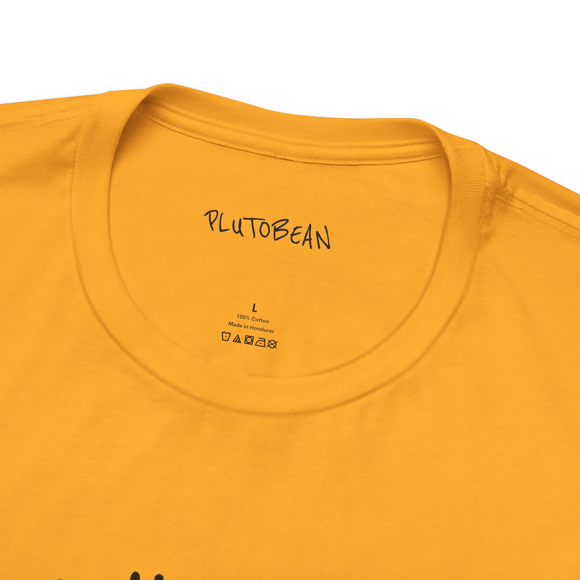 Close-up of neckline and tag on gold ALCHEMIST tee with black lettering