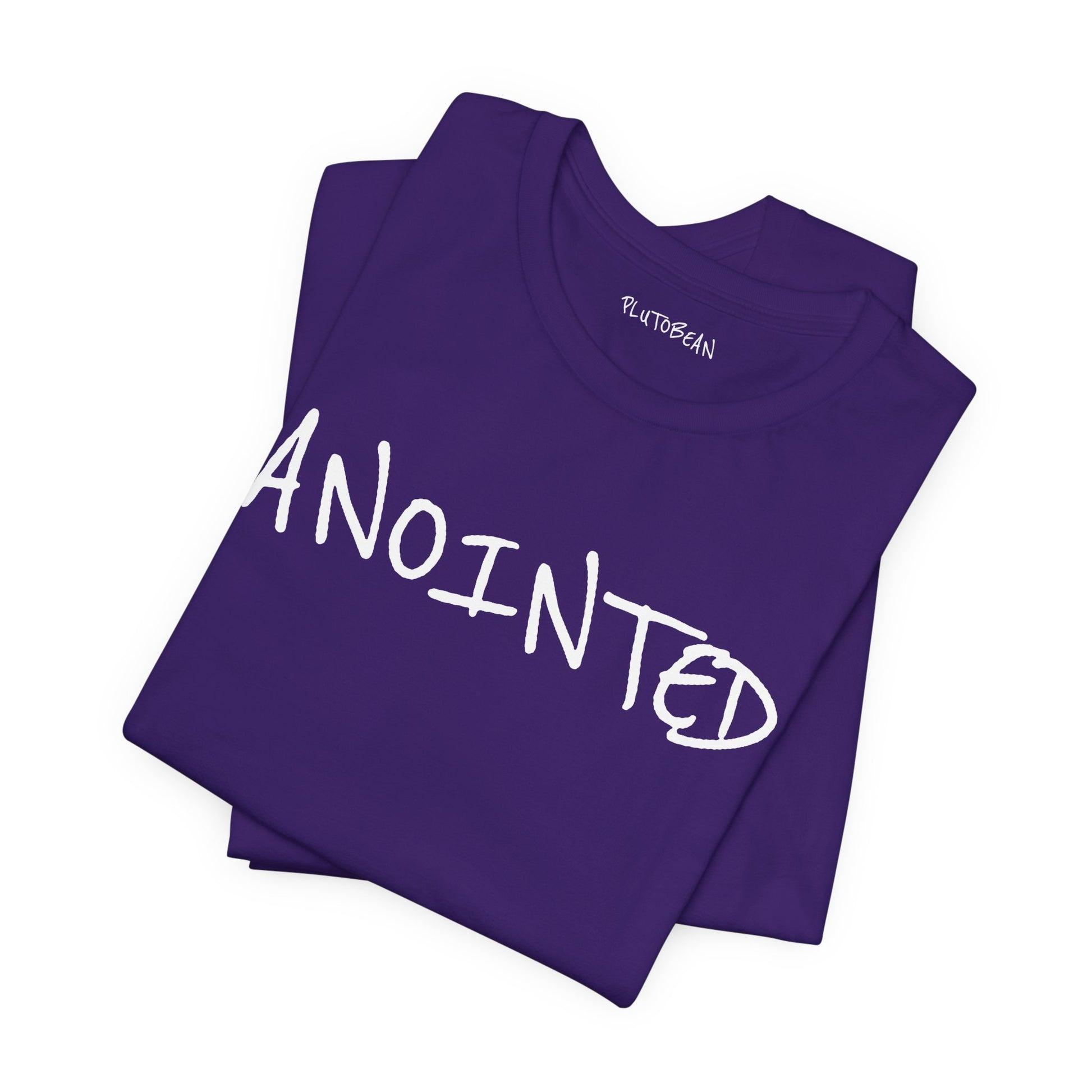 Folded purple tee featuring handwritten “ANOINTED” design in white