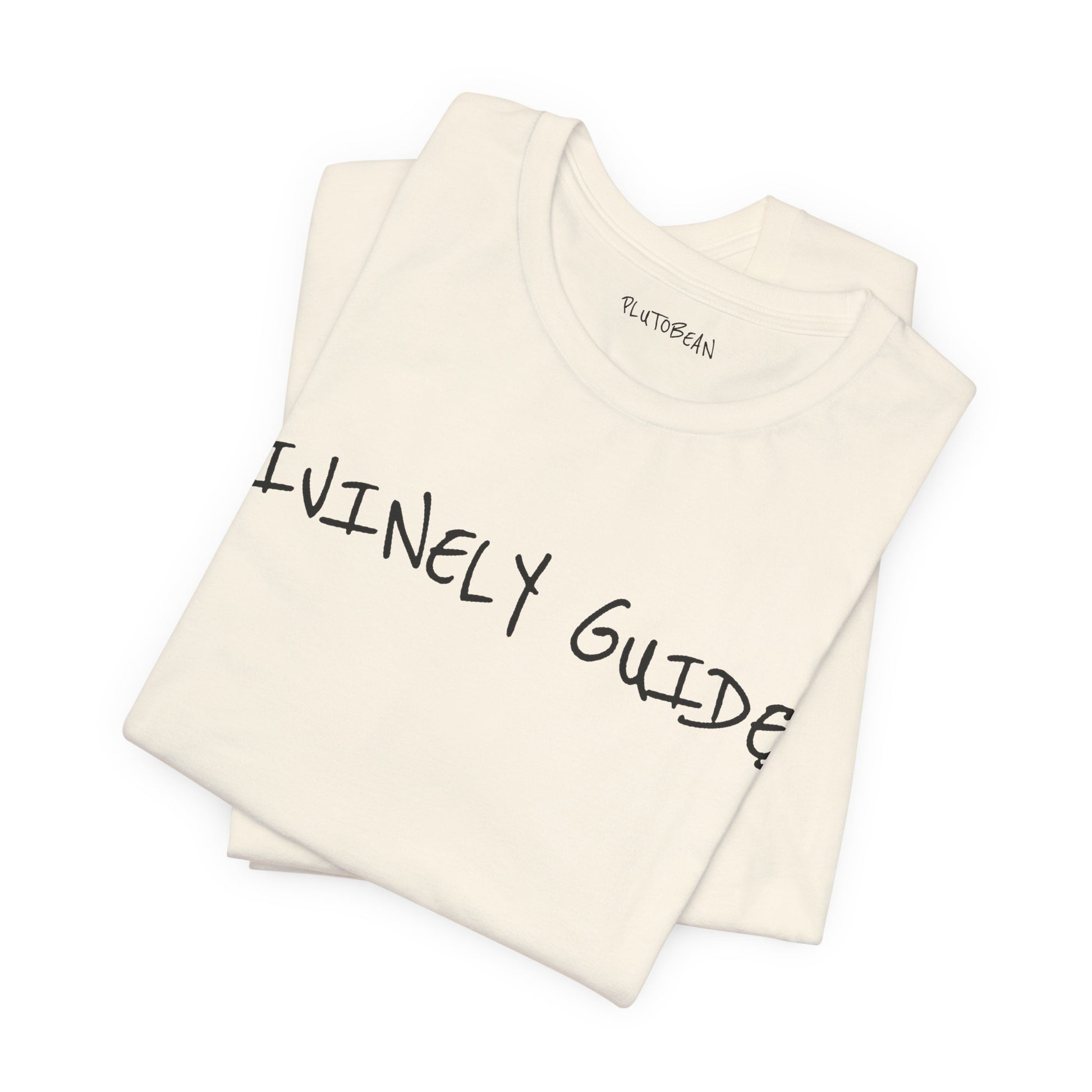 Folded natural tee featuring bold handwritten “DIVINELY GUIDED” graphic