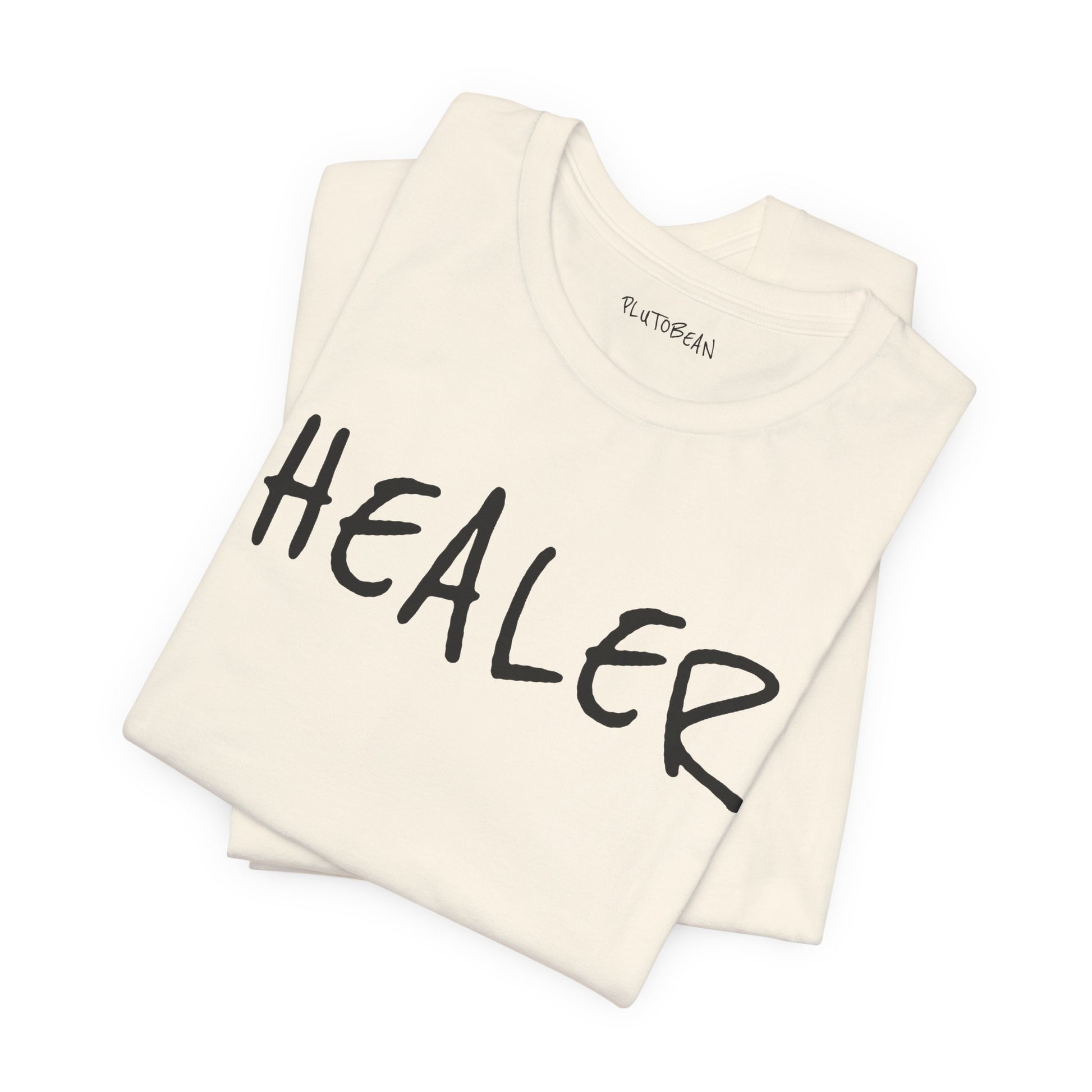 Folded natural tee featuring bold handwritten “HEALER” wordmark in black